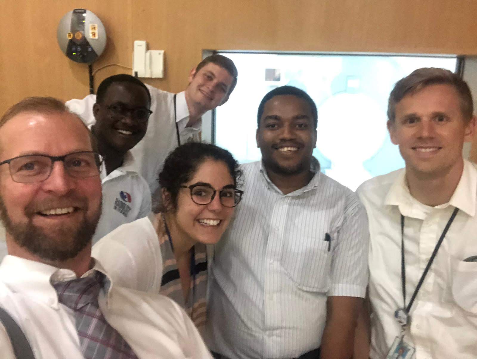 Students and medical professionals pose for a photo inside a Tanzanian hospital.