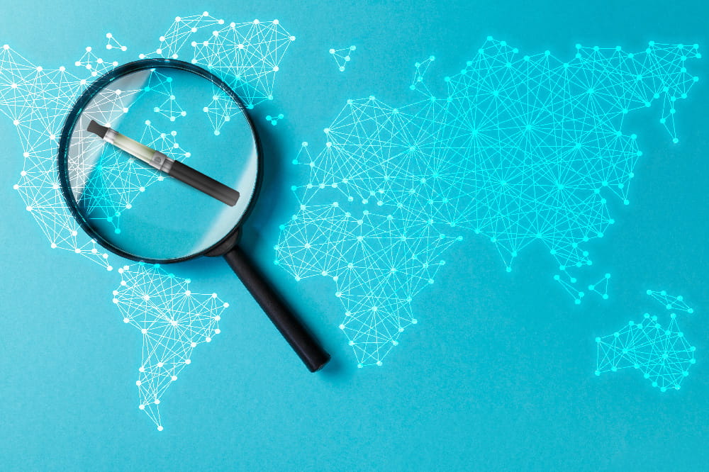vaping pen under a magnifying glass on top of a stylized map of the world
